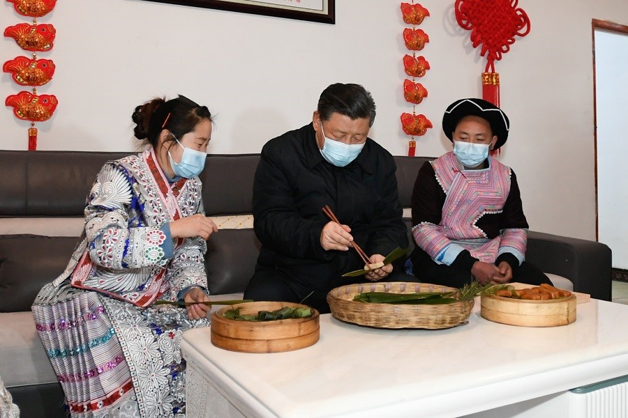 2021年2月3日下午，習(xí)近平在貴州畢節(jié)市黔西縣新仁苗族鄉(xiāng)化屋村苗族村民趙玉學(xué)家，同一家人邊聊家常邊制作當(dāng)?shù)貍鹘y(tǒng)節(jié)日食品黃粑。新華社記者 李學(xué)仁 攝