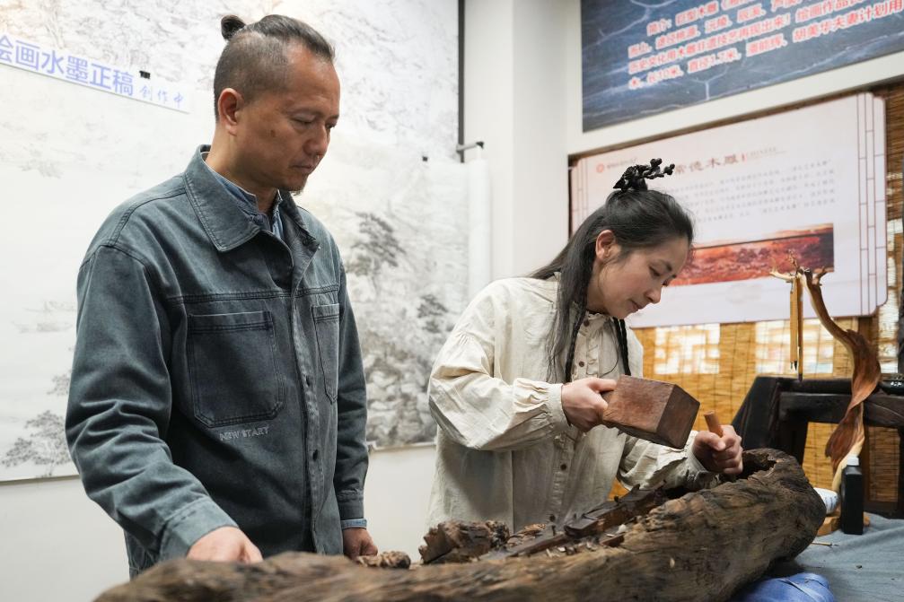 潘能輝和妻子胡美華在湖南常德河街展示木雕。新華社記者 薛宇舸 攝